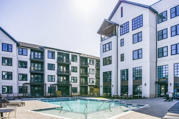 Poolside relaxation area with loungers at Novel Cary Apartments, luxury community offering exclusive amenities for residents