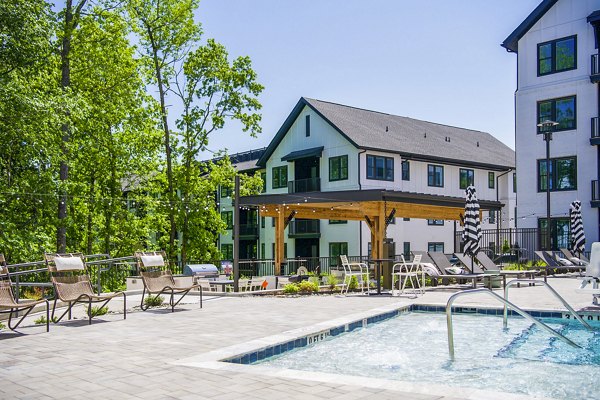 Spacious outdoor pool and patio area at Novel Cary Apartments, offering luxury relaxation spaces for residents