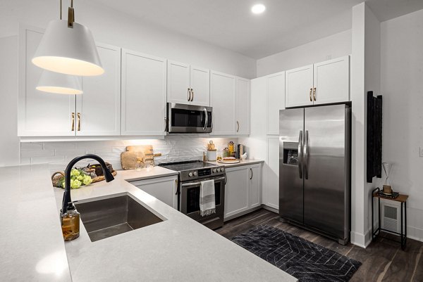 Modern kitchen with stainless steel appliances in The Pace at Holding Village Apartments
