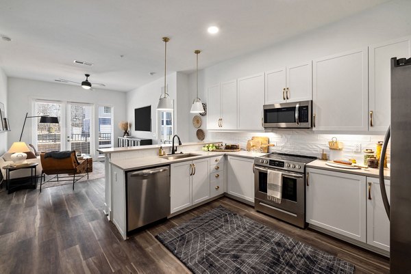 Contemporary kitchen with sleek appliances and quartz countertops at The Pace at Holding Village Apartments