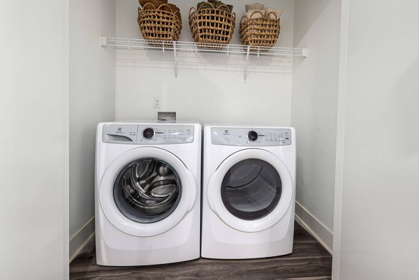 Laundry room with high-efficiency machines at The Pace at Holding Village Apartments
