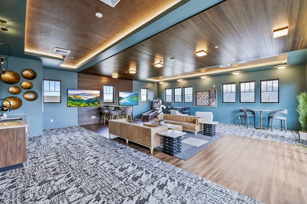 Clubhouse game room with pool table and seating area at Viviano at Riverton Apartments