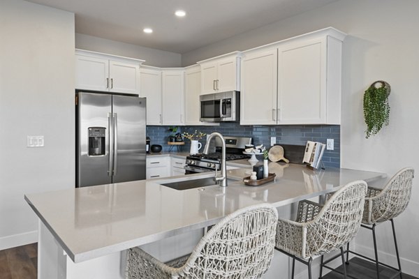 Modern kitchen with sleek countertops and stainless steel appliances at Viviano at Riverton Apartments
