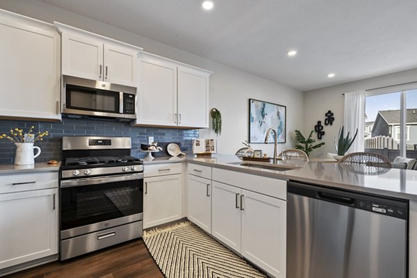 Spacious kitchen with modern appliances and island countertop at Viviano at Riverton Apartments