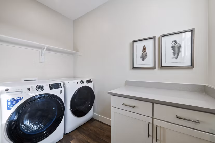 Laundry room featuring modern appliances at Viviano at Riverton Apartments