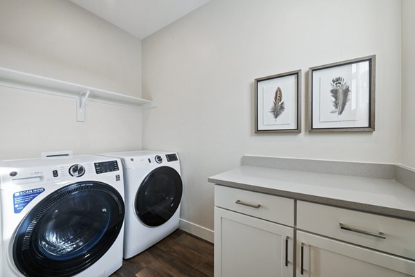 Laundry room featuring modern appliances at Viviano at Riverton Apartments