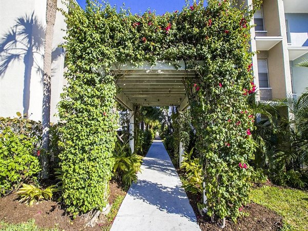 The Laurels Apartments: Cozy patio with contemporary furniture and lush greenery, perfect for enjoying outdoor relaxation moments