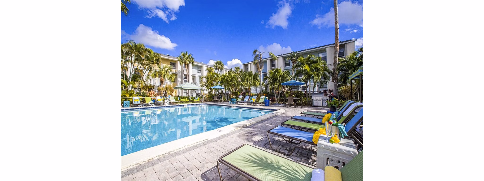 Outdoor pool area with lounge chairs at The Laurels Apartments, offering relaxation and leisure opportunities for residents