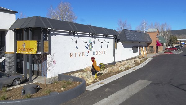 River Roost: Luxury apartment building with a rooster statue at the entrance in a vibrant community