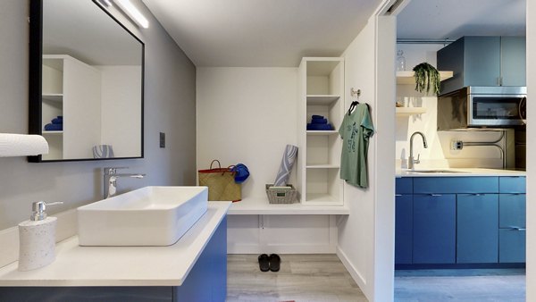 Luxurious bathroom with modern fixtures and elegant tilework at River Roost Apartments, featuring ample natural light and sleek design