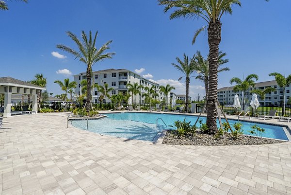Resort-style pool with lounge chairs at The Palms at Cape Coral Apartments