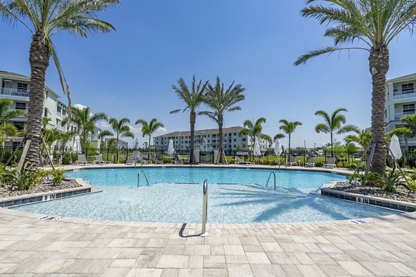 Inviting pool area with lounge chairs at The Palms at Cape Coral Apartments