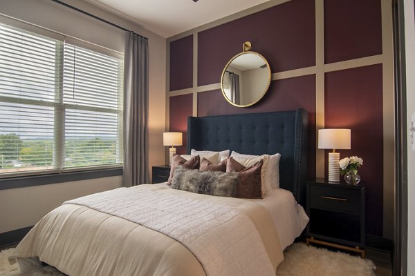 Cozy bedroom with modern furnishings at The Foundry at Mashburn Village Apartments