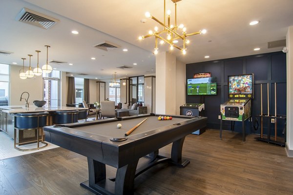 Game room with pool table and lounge seating at The Foundry at Mashburn Village Apartments