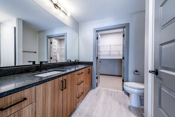 Sleek modern bathroom with large mirror and double sinks at Marlow Apartments