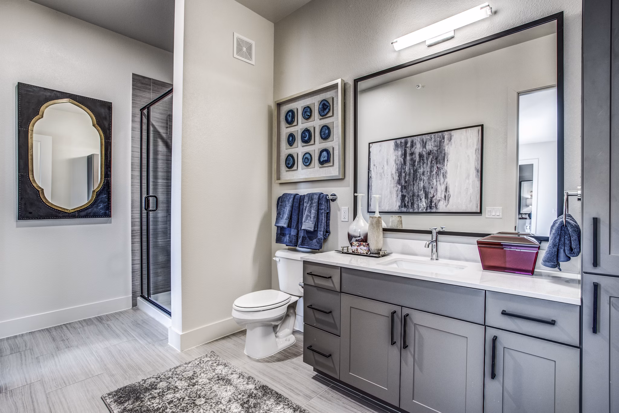 Modern bathroom showcasing sleek fixtures and large mirror in Bluffs at Midway Hollow Apartments