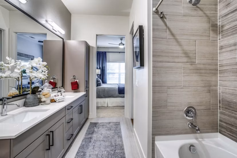 Modern bathroom with marble countertops and spacious shower at Bluffs at Midway Hollow Apartments
