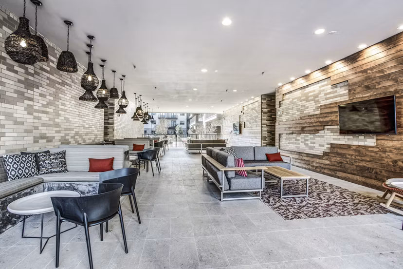 Clubhouse patio with modern seating at Bluffs at Midway Hollow Apartments, a luxury Greystar property with community amenities