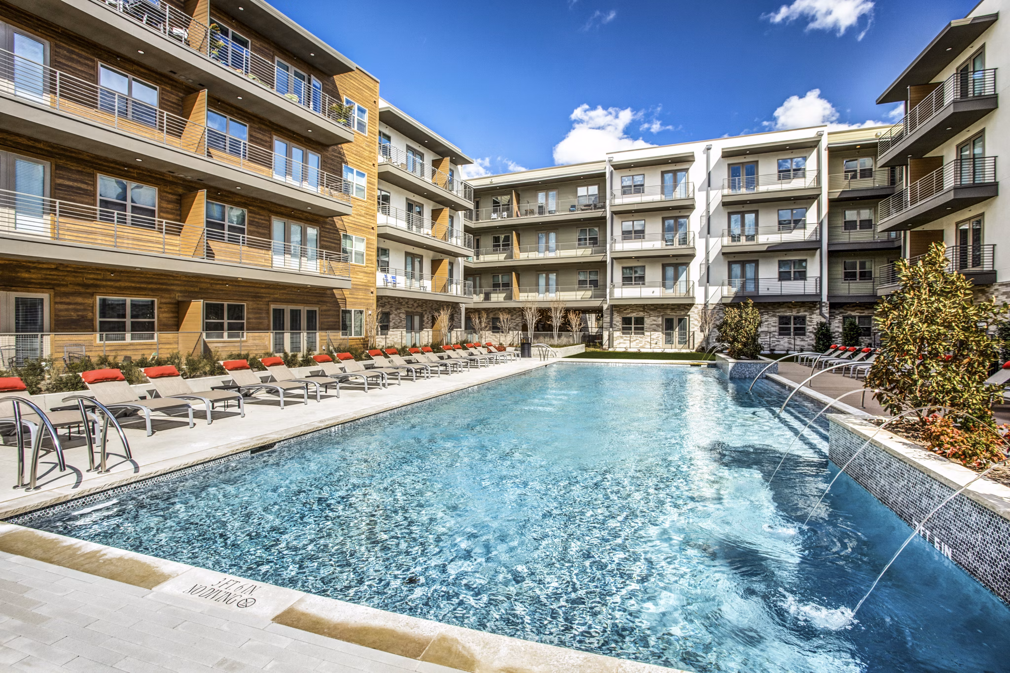 Resort-style pool with lounge chairs at Bluffs at Midway Hollow Apartments