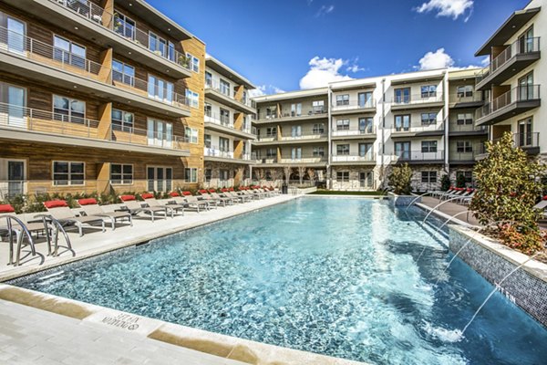 Resort-style pool with lounge chairs at Bluffs at Midway Hollow Apartments