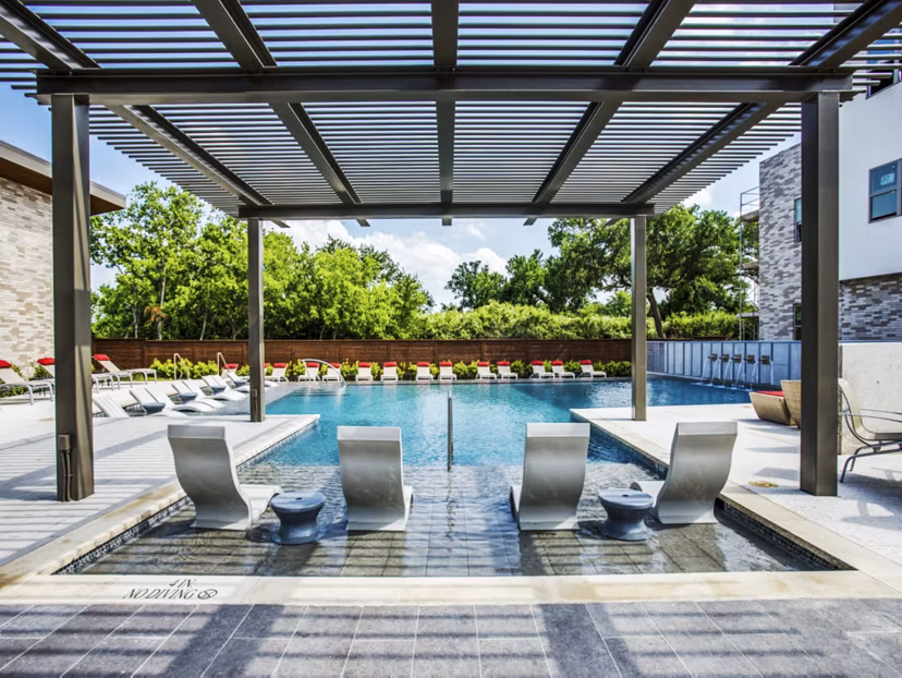 Serene outdoor pool at Bluffs at Midway Hollow Apartments with lush surroundings creating a relaxing retreat