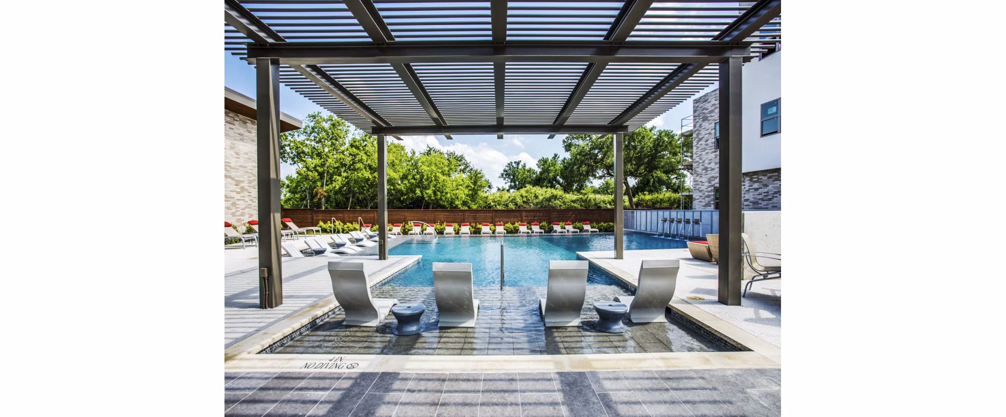 Serene outdoor pool at Bluffs at Midway Hollow Apartments with lush surroundings creating a relaxing retreat