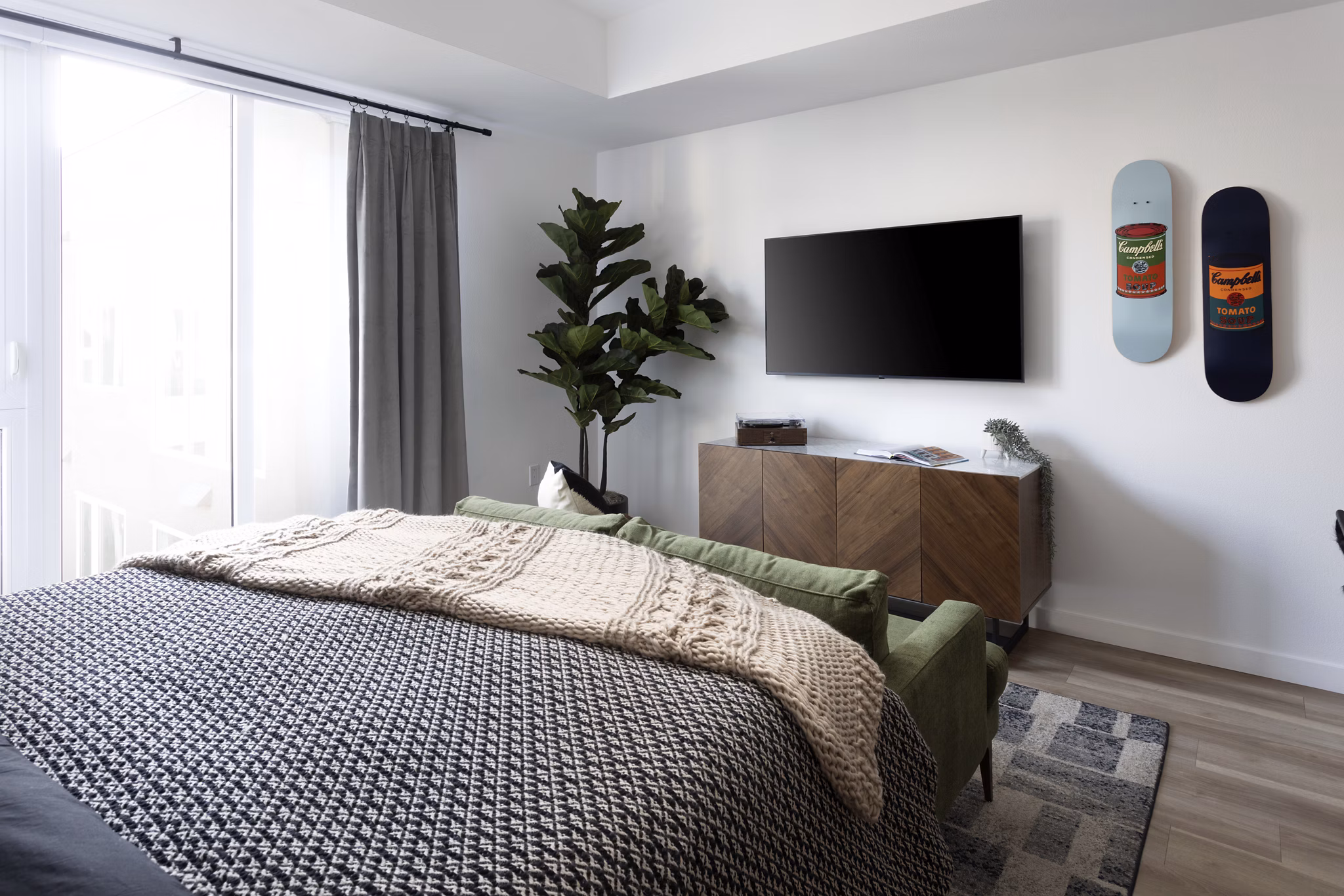Elegant bedroom with modern decor and large windows at The Louise 4900 Apartments in Seattle