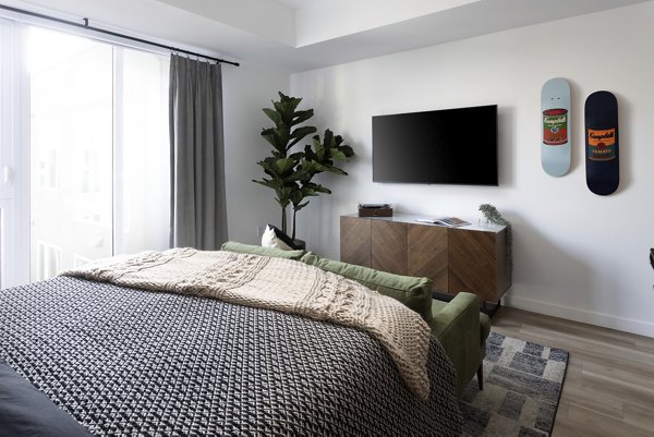 Elegant bedroom with modern decor and large windows at The Louise 4900 Apartments in Seattle