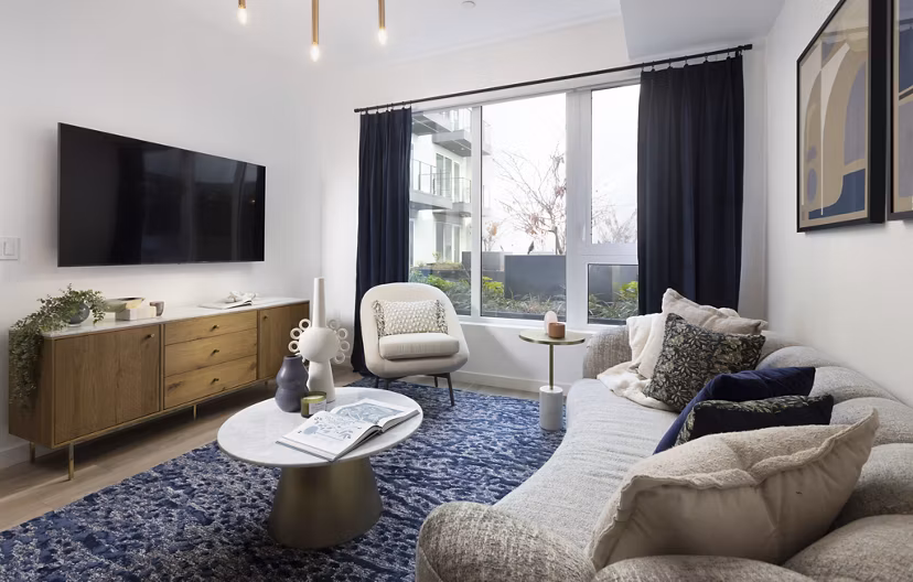 Stylish living room with modern decor and ample natural light at The Louise 4900 Apartments, offering luxury living experiences