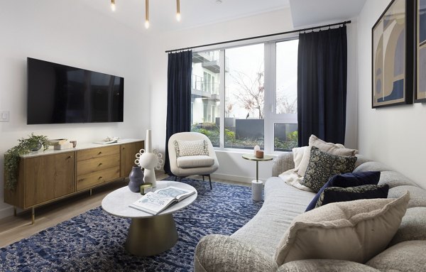 Stylish living room with modern decor and ample natural light at The Louise 4900 Apartments, offering luxury living experiences