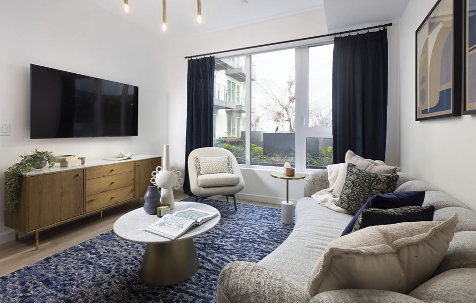 Stylish living room with modern decor and ample natural light at The Louise 4900 Apartments, offering luxury living experiences