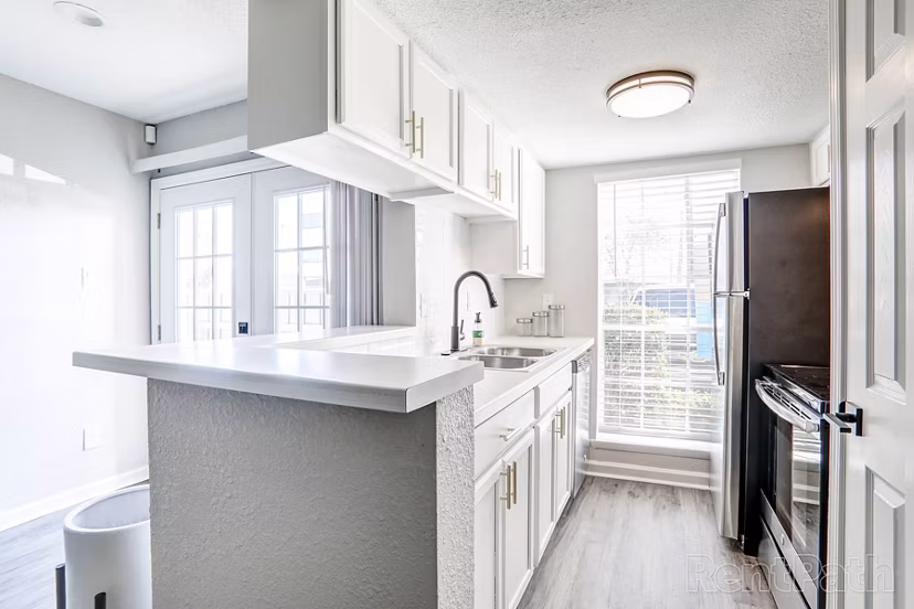 Modern kitchen with stainless steel appliances and sleek countertops at The Lumiere Apartments