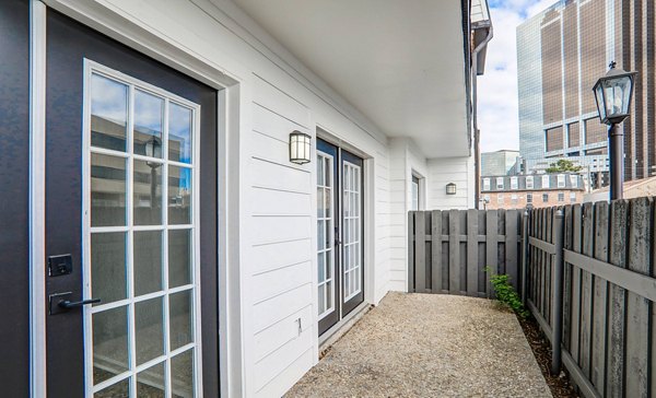 Modern outdoor patio with seating and garden at The Lumiere Apartments