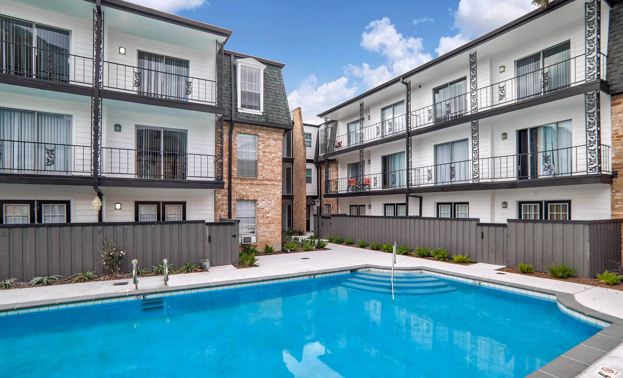 Pool with stylish loungers at The Lumiere Apartments offering luxury outdoor relaxation