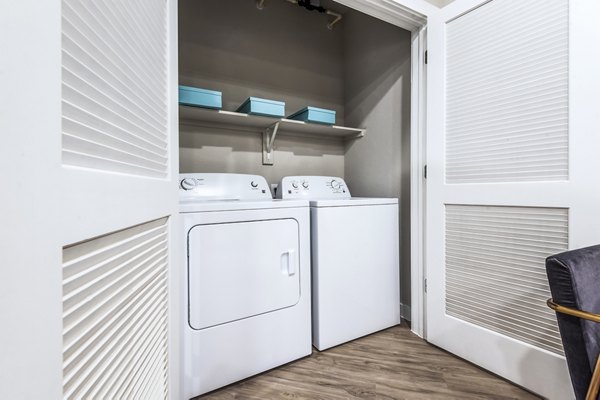 Laundry room with high-efficiency washers and dryers at Tribute at the Rim Apartments, offering convenience and modern amenities for residents