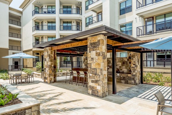 Patio and grill area at Tribute at the Rim Apartments featuring modern outdoor seating and scenic views