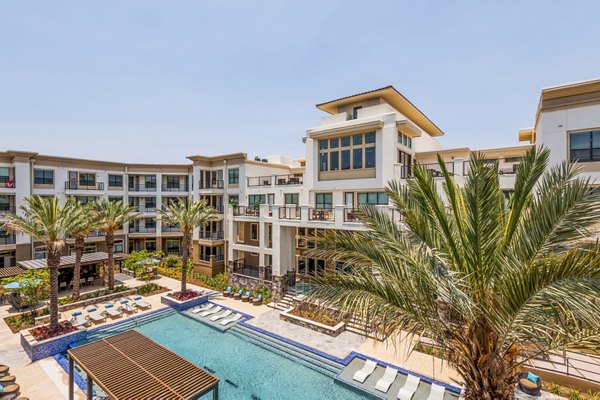 Spacious outdoor pool with lounge chairs at Tribute at the Rim Apartments