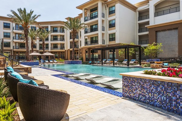 Modern outdoor pool with lounge chairs at Tribute at the Rim Apartments