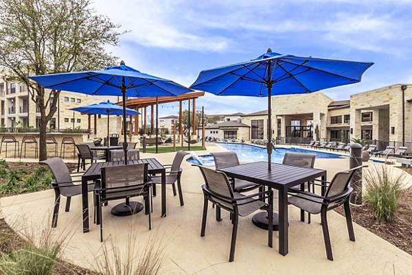 Outdoor patio with cozy seating at TruNorth at Bulverde Apartments, perfect for relaxation and socializing in a luxurious community setting