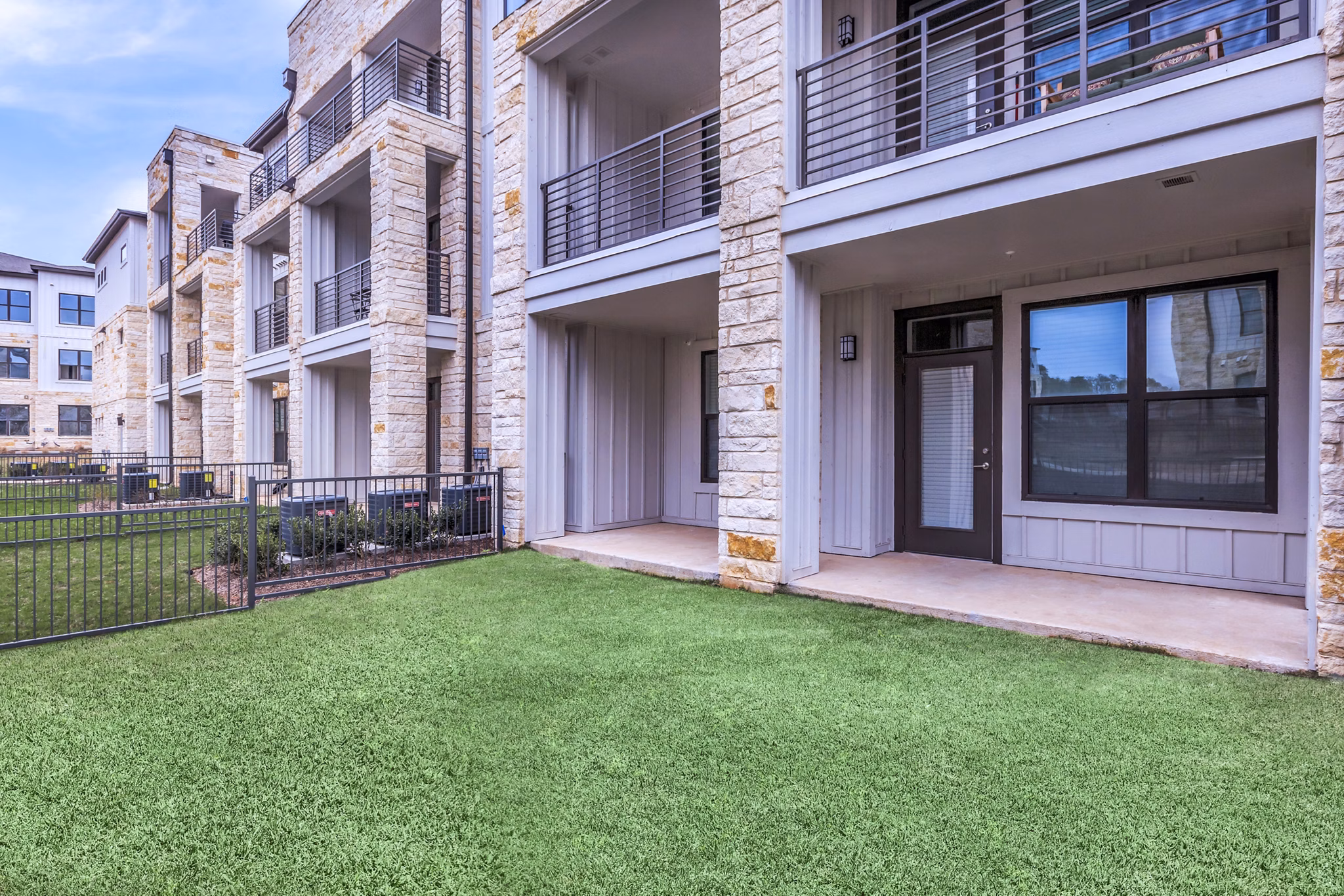 TruNorth at Bulverde Apartments: Modern patio with cozy seating and greenery in a luxury apartment setting