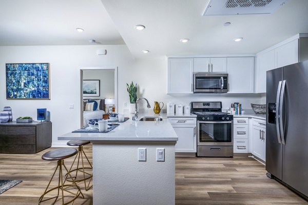 Modern kitchen featuring stainless steel appliances and marble countertops in Azul Chula Vista Apartments