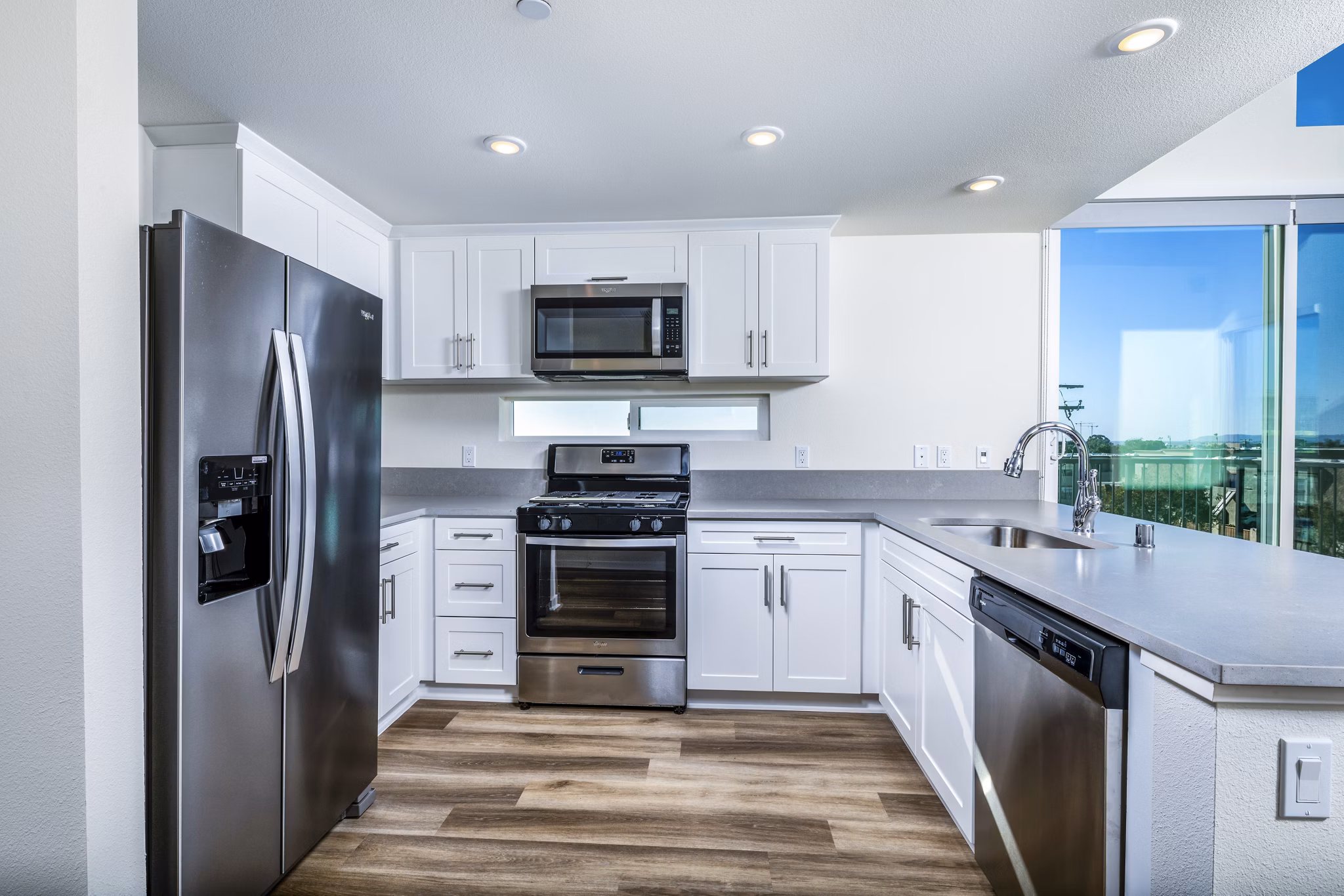 Modern kitchen with stainless steel appliances and granite countertops at Azul Chula Vista Apartments