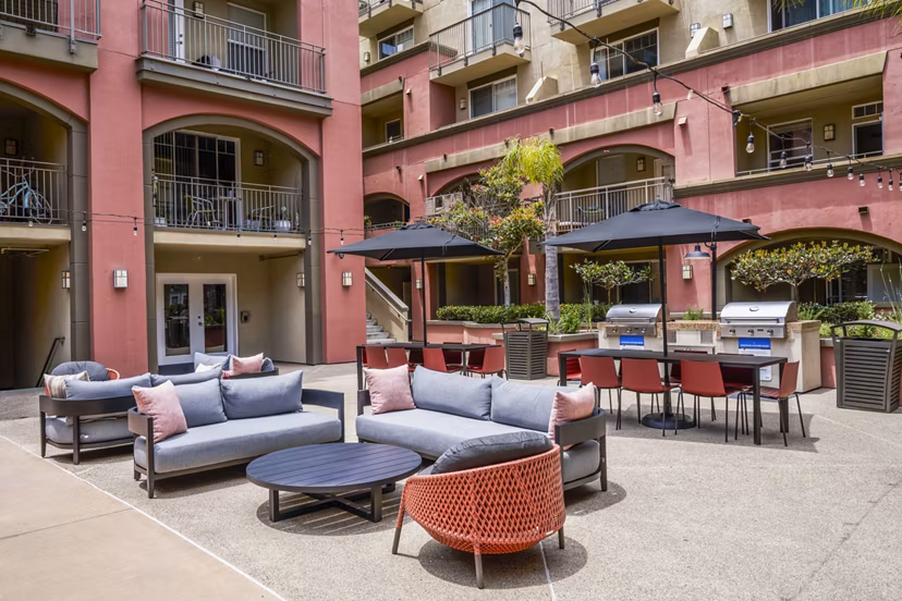 Grill area with outdoor seating on patio at Gema Apartments