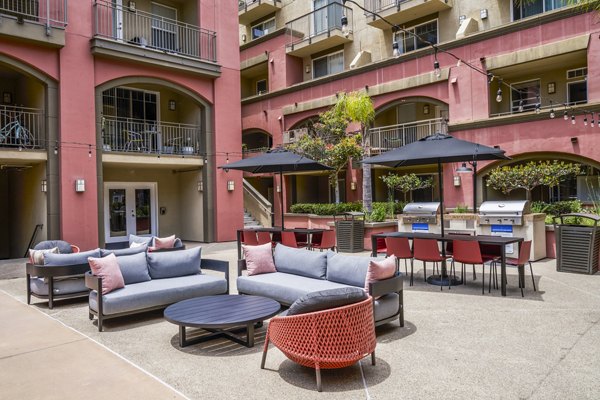 Grill area with outdoor seating on patio at Gema Apartments