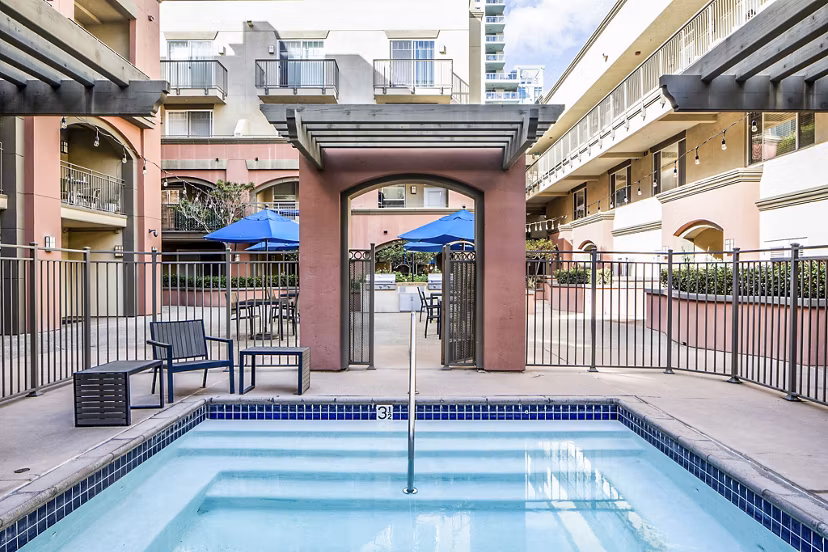 Resort-style pool with lounge chairs at The Heritage Apartments, offering luxurious outdoor relaxation for residents