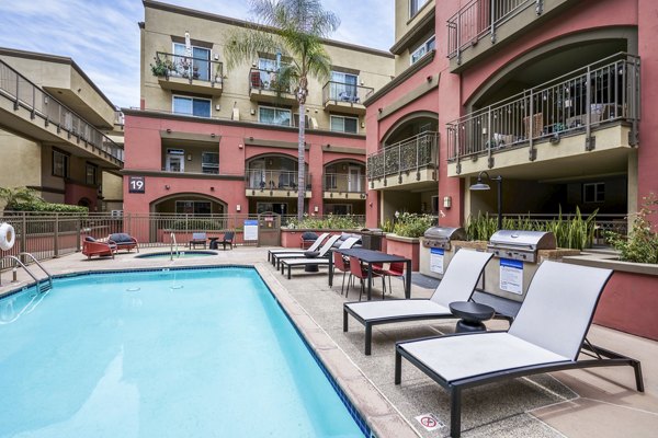 Outdoor grill area beside large pool at Gema Apartments, perfect for gatherings and relaxation