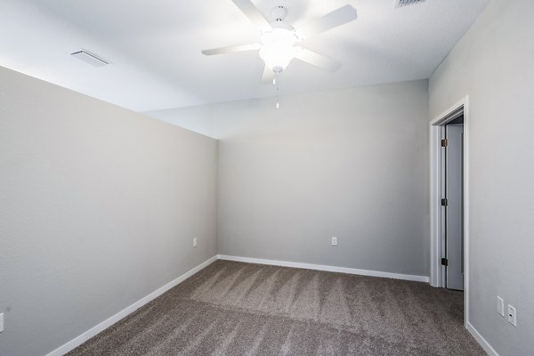 Elegant bedroom with large windows at Parkside at Avalon Park Apartments, offering luxury living in a serene setting
