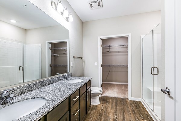 Modern bathroom with marble countertops and glass shower at Parkside at Avalon Park Apartments
