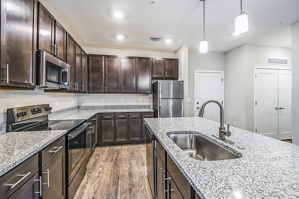 Kitchens at Parkside at Avalon Park Apartments featuring granite countertops and stainless steel appliances