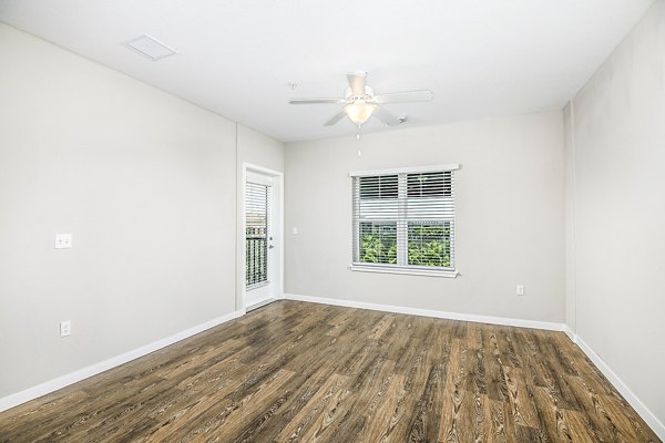 Spacious living room with modern decor and large windows in Parkside at Avalon Park Apartments